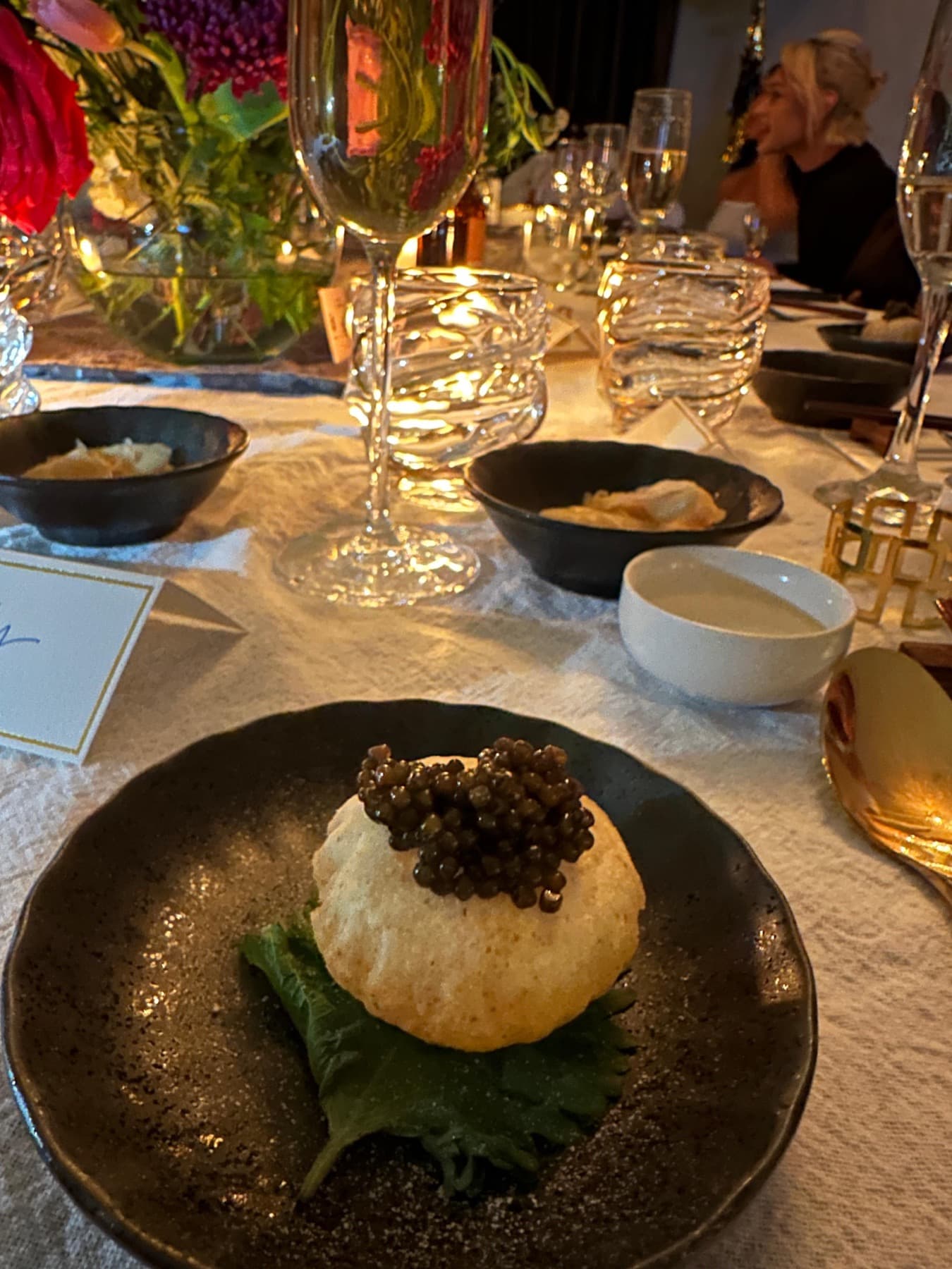 Caviar over a rice puff on a shiso leaf